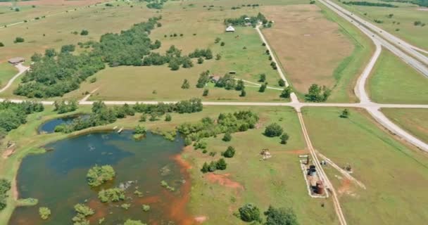 位于俄克拉荷马州克林顿市历史路66号附近的一个小池塘里的油泵，在空中俯瞰风景 — 图库视频影像