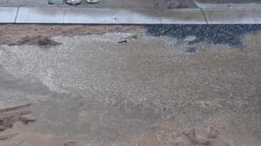 Büyük bir su birikintisinin içinden fırtına sırasında yolu sel basmış.