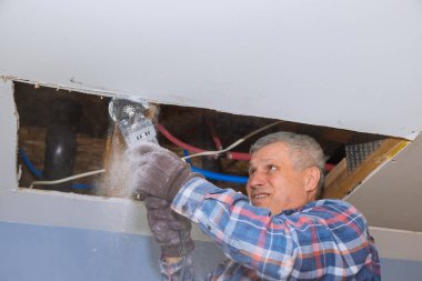 Açı el elektrikli elektrikli aletler ile hasar görmüş alçı taşı alçı tabaka kesimi