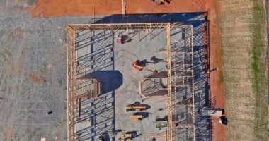 İnşaat halindeki beton bloklar için asansör boşluğunun havadan görünüşü işçilere taş koyuyor