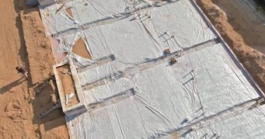 Plastik su boruları inşaat alanındaki kum temeli üzerine kurulmuştu.