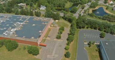 Aerial panoramic overview of solar system on a roof building warehouse near American small town