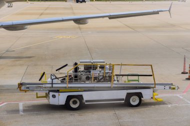 Airport ground service on conveyor belt to an airplane outdoors a daytime