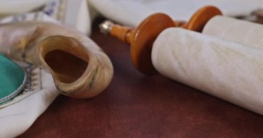 Prayer shawl in the shofar horn on torah scroll with Jewish religious symbols pray