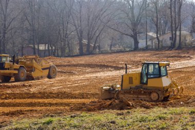 Arazinin ağır traktör makinelerinin toprak taşıdığı yeni bir inşaat sahasına hazırlanması