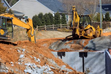 Yerel otoyolda beton drenaj kanalı döşeyen yeniden inşa yolu.