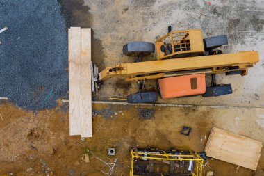 İnşaat alanı kalaslı forklift kamyonu, endüstriyel taşımacılığın yardımıyla ahşap bir kontrplak yüklemesi.
