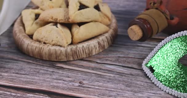 Fiesta tradicional en la fiesta judía Purim en el hamantaschen galletas, ruidoso y carnaval máscara — Vídeo de stock