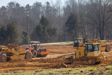 Kazıcı, inşaat alanında toprak taşıma ve peyzaj işleri yapıyor.