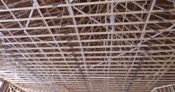 Charpente de toit en hauteur travailleurs clouant des poutres en bois sur le toit — Video