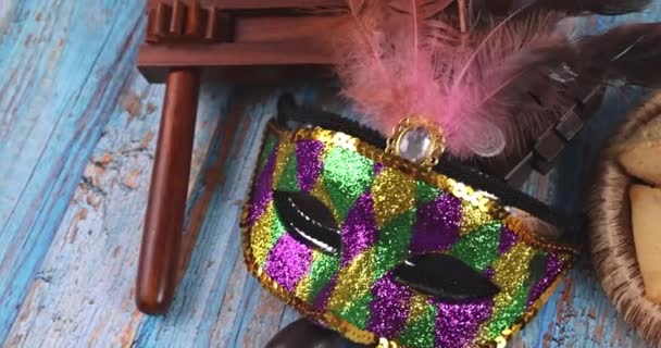 Jewish carnival Purim celebration on hamantaschen cookies, noisemaker and mask with parchment — Stock Video