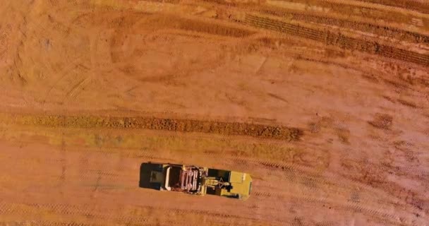 Тяжёлый тракторный экскаватор выравнивает землю, выполняя озеленение. — стоковое видео