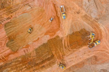 Panoramik üst görünüm iş kepçesi toprak kazma ve inşaat alanında toprak dolu bir çöp kamyonu yükleme
