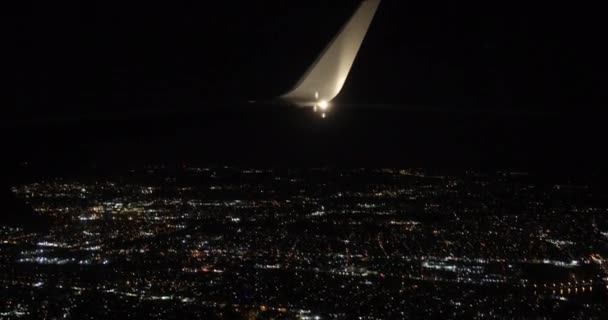 Vue depuis un avion volant par la fenêtre de la ville la nuit — Video