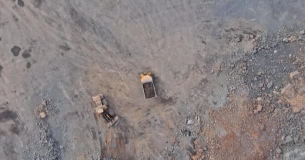 Bagger verlädt bei Erdarbeiten das abgebaute Gestein im Kipper für Steinbrechmaschine — Stockvideo