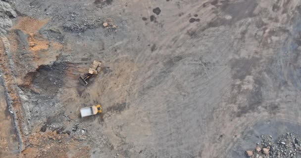 Pemandangan udara di tambang, ekskavator dan truk buangan selama pemuatan batu yang ditambang. — Stok Video
