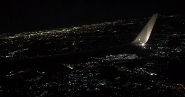 Wing view of passenger aiplane taking off at night city lights seen below. — Stock Video