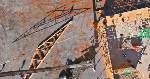 Vista aérea de techo de madera con grúa sostiene un techo vigas de armadura para la instalación — Vídeo de stock