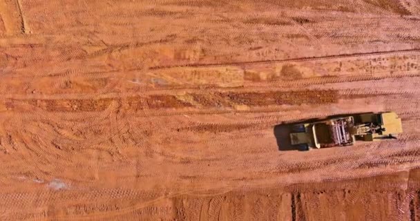 Важка тракторна техніка екскаватор вирівнює землю, роблячи озеленення — стокове відео