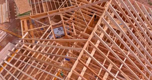 Vista aerea dall'alto della costruzione che lavora sulle travi del tetto della casa costruita in legno in costruzione — Video Stock