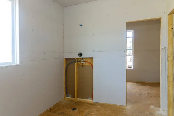 Installing gypsum plasterboard drywall for inside walls in new home is under construction