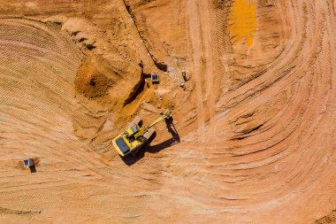 Kazıcı kepçeyle çalışıyor. Fırtınalı su çukurları hijyenik kanalizasyon sistemi inşaatı ile yeni yerleşim kompleks binaları için hazırlık zemini kazıyor.
