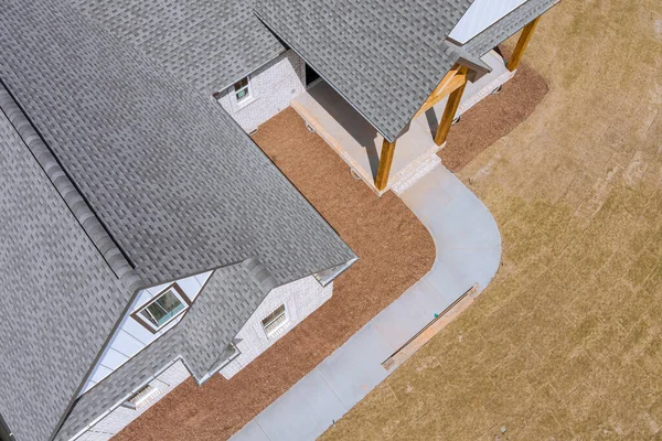 Techo recién instalado con tejas de asfalto con azulejos de betún en la azotea en un nuevo hogar —  Fotos de Stock
