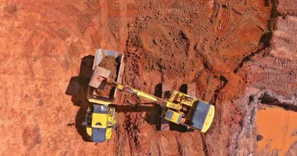 Excavator scoop loads a soil in dump truck on preparing place to construction site for residential complex house — Stock Video