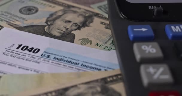 Formulario de declaración de impuestos del IRS 1040 con billetes en dólares estadounidenses en primer plano — Vídeo de stock