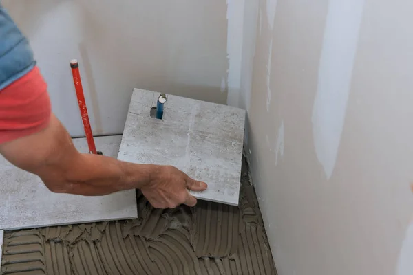 Home melhoria construção trabalhador azulejos leigos piso de cerâmica — Fotografia de Stock