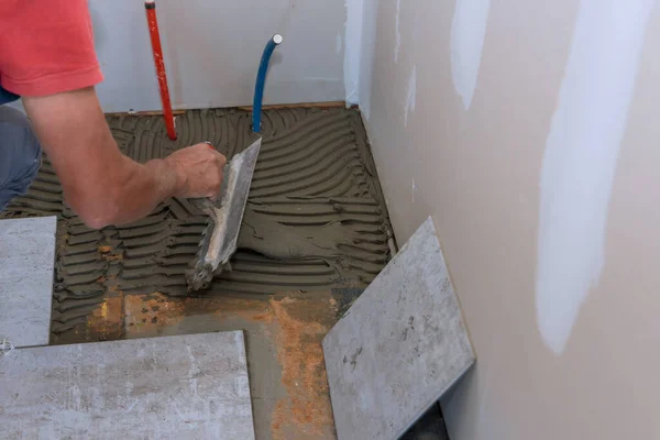 Proceso de colocación de baldosas de cerámica de piso, aplicación de la base adhesiva — Foto de Stock