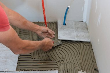 adam seramik zemini bulunduğu yapıştırıcı yerleştirerek.