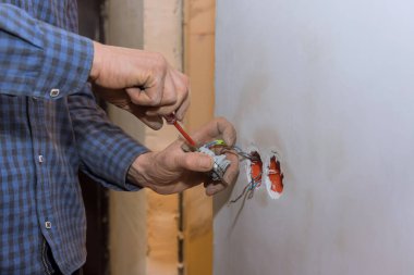 Elektrikçi aydınlatma anahtarı duvardaki yükler.