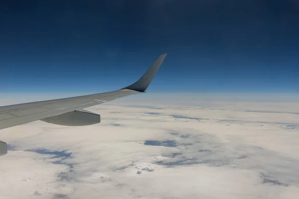 雲の上の翼の飛行機の窓からの飛行旅行ビュー青空 — ストック写真