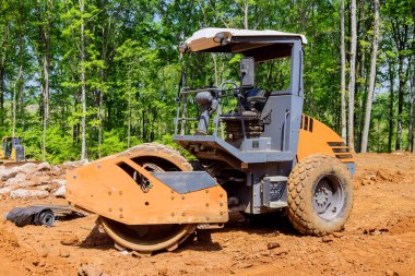 Arazinin inşaat alanı için hazırlanması. Ağır traktör makineleri toprak taşır.