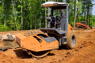 İnşaat alanı için ağır traktör kazıcılı hazırlık arazisi peyzaj yaparak yeryüzünü hizaladı.