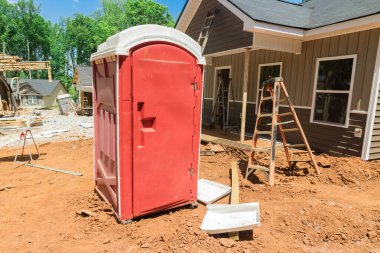 Open portable toilet at construction site for worker.