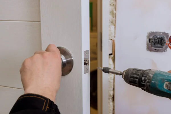 Locksmith hand holds the screwdriver in installing new house door lock — Foto de Stock