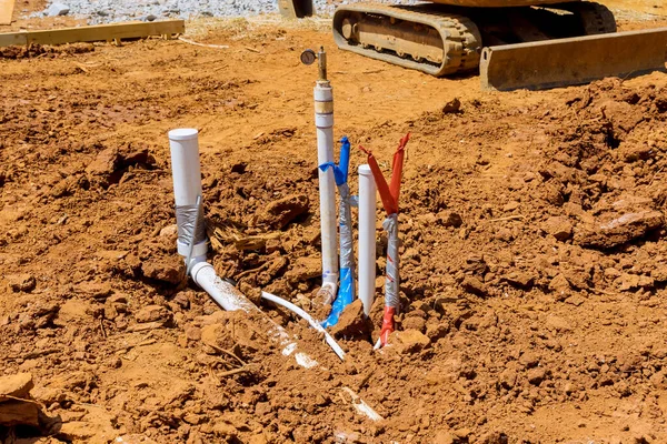 New residential home with laying sewer pipes and water pipe in the ground under the foundation — Stok fotoğraf