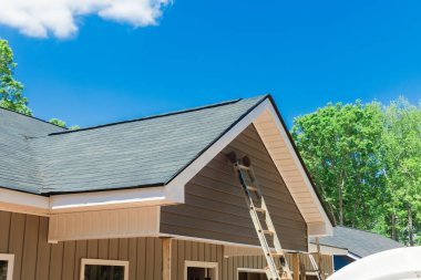 Çatıda asfalt kiremitlerle kaplı çatı inşaatı yeni ev.