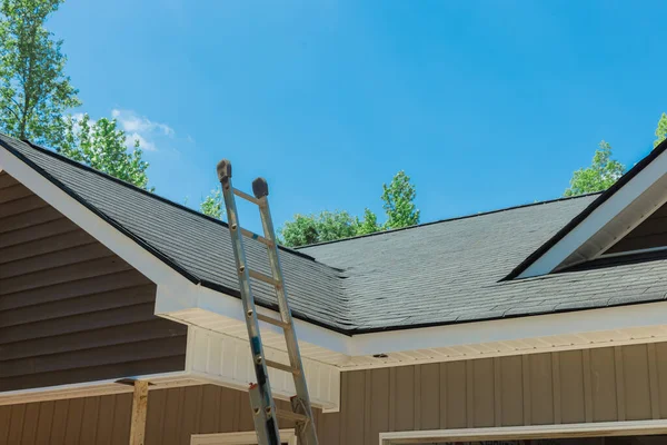Newly installed roof with asphalt shingles with bitumen tiles on the rooftop on new home — Stock Photo, Image