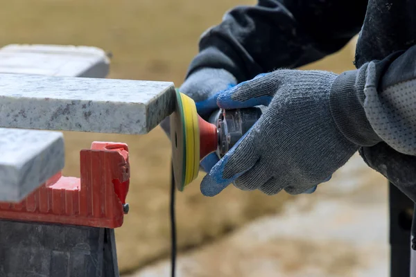 El maestro trabaja con una piedra de granito usando una amoladora — Foto de Stock