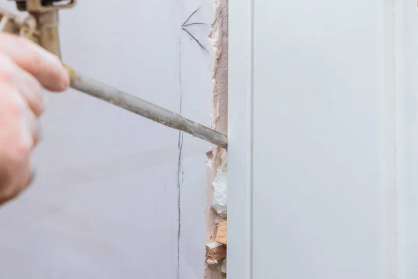 Handyman instalando puerta con una espuma de montaje en una habitación — Foto de Stock