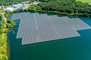 Solar farm panels in aerial view, array of polycrystalline photovoltaics in solar power plant floating on the water in lake