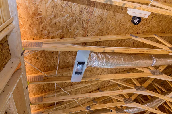 Ventilation pipes in silver insulation material hanging from the ceiling inside new building. — Stock Photo, Image