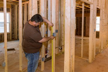 Elektrikçinin elleri yeni daireye elektrik prizi takıyor.