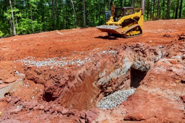 Tekerlek yükleyicisi, inşaat alanındaki çakılları dışarı taşıyor.
