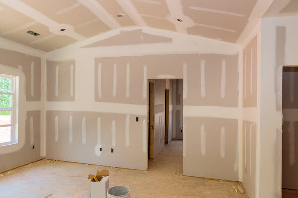 Finishing plastering drywall in ready for paint with new house