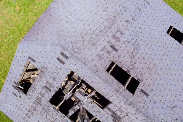 Telhas com azulejos danificados com telhas quebradas e um buraco no telhado — Fotografia de Stock