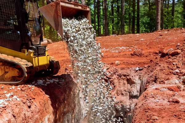 Kazı makinesi inşaat alanında çalışıyor. Taş çakıl boşaltıyor.